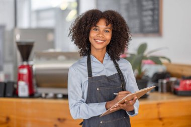 Afrikalı kadın kahve dükkanı küçük işletme sahibi tezgahın önünde durup stok kontrolü yapıyor. afro saç çalışanı Barista girişimci.