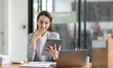 Bir ofis masası, vergi, rapor, muhasebe, istatistik ve analitik araştırma konseptinde matematik finansmanı yapmak için hesap makinesi ve laptop kullanan mutlu Asyalı iş kadını