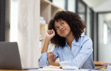Başarılı Afro-Amerikan muhasebeci kadın ofisteki dizüstü bilgisayardan evrak vergisi alıyor. Yatırım ekonomisi ve pazarlama araştırma kavramını finanse et.
