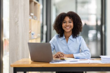 Başarılı Afro-Amerikan muhasebeci kadın ofisteki dizüstü bilgisayardan evrak vergisi alıyor. Yatırım ekonomisi ve pazarlama araştırma kavramını finanse et.
