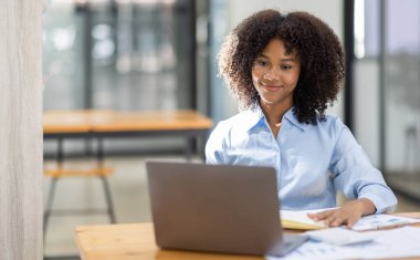 Başarılı Afro-Amerikan muhasebeci kadın ofisteki dizüstü bilgisayardan evrak vergisi alıyor. Yatırım ekonomisi ve pazarlama araştırma kavramını finanse et.