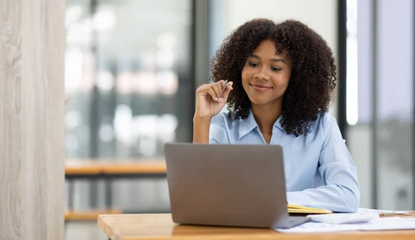 Başarılı Afro-Amerikan muhasebeci kadın ofisteki dizüstü bilgisayardan evrak vergisi alıyor. Yatırım ekonomisi ve pazarlama araştırma kavramını finanse et.