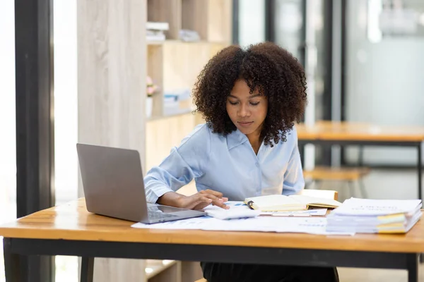 stock image Successful african american accountant business woman work documents tax on laptop computer in office. finance investment economy and marketing research concept.