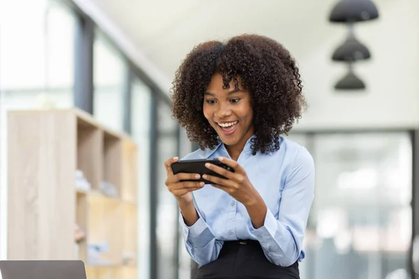 stock image Beautiful asian african businesswoman using phone and sitting at office desk, 