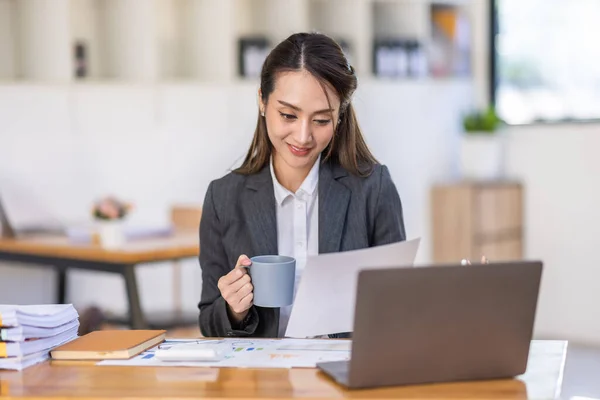 stock image Cheerful Asian business woman work in workspace office. do math finance on wooden desk in office, tax, accounting, financial concept.