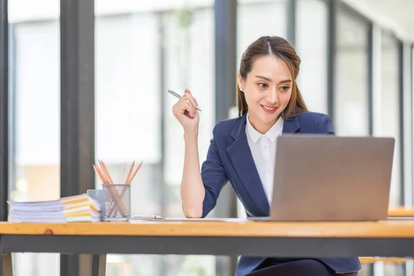 stock image Brown haired wearing light blue jacket smiling Asian woman work with document laptop in office, doing planning analyzing the financial report, business plan investment, finance analysis concept.