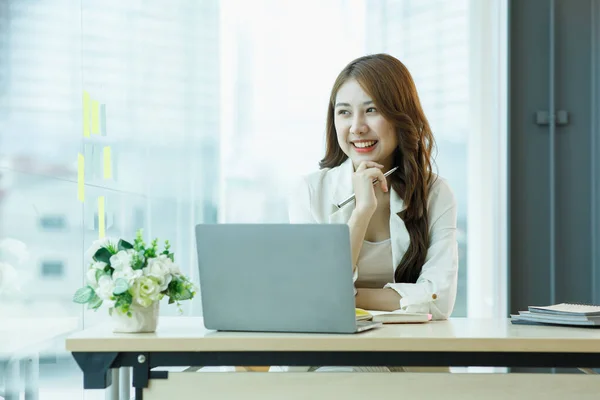 stock image Smiling Cute asian woman working laptop happy for success. Attractive Happy female employee in the office or co-working space with copy space for label text.
