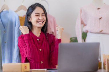 Kuruluş KOBİ küçük iş girişimcisi serbest Asyalı bir kadın dizüstü bilgisayarda çalışıyor neşeli bir başarıyla Asyalı kadın elini kaldırıyor online pazarlama paketleme ve dağıtım fikri KOBİ 'yi heyecanlandırıyor