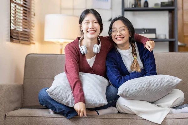 stock image Young adult happy smiling Hispanic Two Asian student wearing headphones talking on online chat meeting using laptop in university campus or at virtual office. College female student learning remotely.