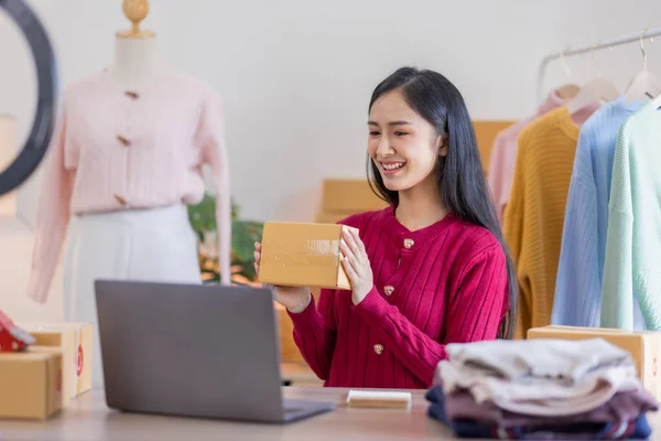 stock image Asian women SME selling clothes online, She is answering customers' questions by phone and laptop at home, Starting Small business entrepreneur freelance, Online business, SME concept.