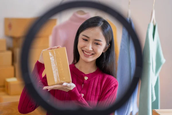 İnternette kıyafet satan Asyalı kadın KOBİ 'ler, evde telefon ve dizüstü bilgisayarla müşterilerin sorularını cevaplıyor, küçük işletme girişimciliği, Çevrimiçi ticaret, KOBİ konsepti.