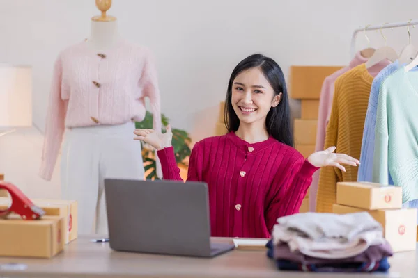 stock image Asian women SME selling clothes online, She is answering customers' questions by phone and laptop at home, Starting Small business entrepreneur freelance, Online business, SME concept.