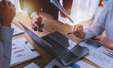 Finansal analistler, şirketlerin başarılı takım çalışmalarının sonuçlarını gösteren bir toplantıda bir dijital tablet planlama yatırım projesinin ticari mali raporlarını analiz ediyorlar..