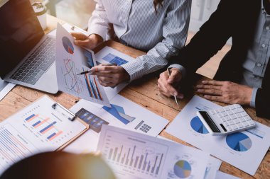 Finansal analistler, şirketlerin başarılı takım çalışmalarının sonuçlarını gösteren bir toplantıda bir dijital tablet planlama yatırım projesinin ticari mali raporlarını analiz ediyorlar..