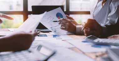 Finansal analistler, şirketlerin başarılı takım çalışmalarının sonuçlarını gösteren bir toplantıda bir dijital tablet planlama yatırım projesinin ticari mali raporlarını analiz ediyorlar..