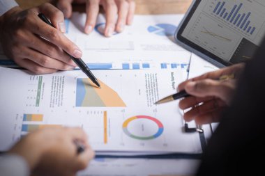 Finansal analistler, şirketlerin başarılı takım çalışmalarının sonuçlarını gösteren bir toplantıda bir dijital tablet planlama yatırım projesinin ticari mali raporlarını analiz ediyorlar..