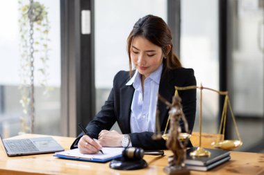 Business Asian woman in suit and Lawyer working on a documents at workplace office. Judge gavel with Justice lawyers,  Legal law, advice  and justice concept