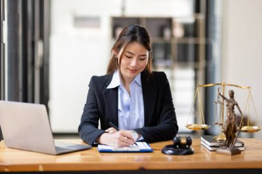 Business Asian woman in suit and Lawyer working on a documents at workplace office. Judge gavel with Justice lawyers,  Legal law, advice  and justice concept