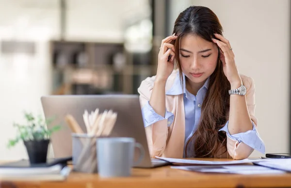 Young business Asian women are stressed while working on laptop, Tired asian businesswoman with headache at office, feeling sick at work copy space in workplace an home office.