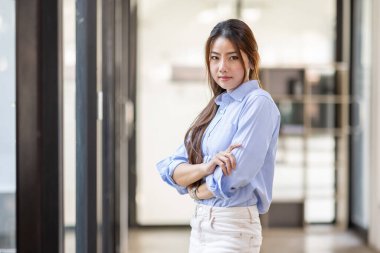 Portrait of Young confident smiling Asian business woman leader, successful entrepreneur, elegant professional company executive ceo manager, standing in office.