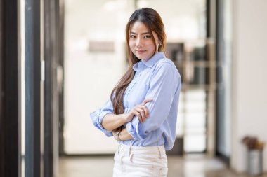 Portrait of Young confident smiling Asian business woman leader, successful entrepreneur, elegant professional company executive ceo manager, standing in office.