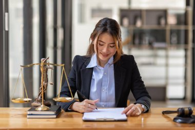 justice and law concept. Lawyer office. Statue of Justice with scales and lawyer Asian Woman working on a laptop. Legal law, advice and justice concept.