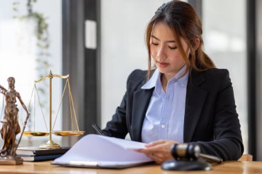 justice and law concept. Lawyer office. Statue of Justice with scales and lawyer Asian Woman working on a laptop. Legal law, advice and justice concept.