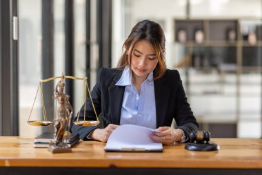 justice and law concept. Lawyer office. Statue of Justice with scales and lawyer Asian Woman working on a laptop. Legal law, advice and justice concept.