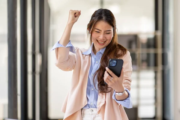 happy excited.Portrait of success business asian woman enjoy success with laptop on work desk. Authentic shot joyful asian girl got jackpot, Surprised and celebrating her victory.