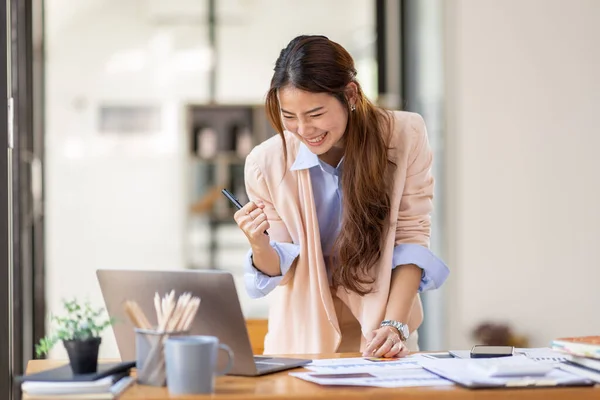 happy excited.Portrait of success business asian woman enjoy success with laptop on work desk. Authentic shot joyful asian girl got jackpot, Surprised and celebrating her victory.