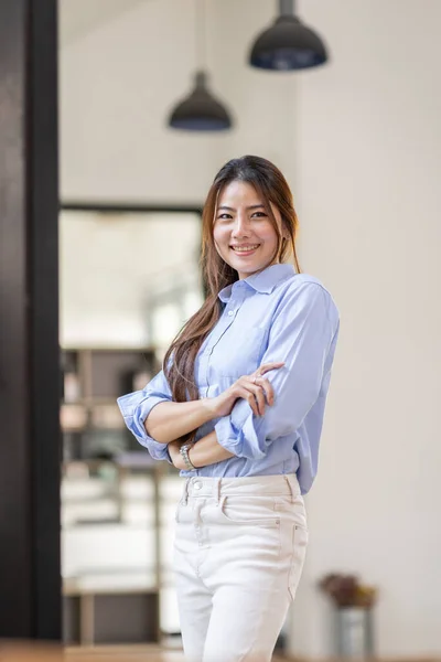 Portrait of Young confident smiling Asian business woman leader, successful entrepreneur, elegant professional company executive ceo manager, standing in office.
