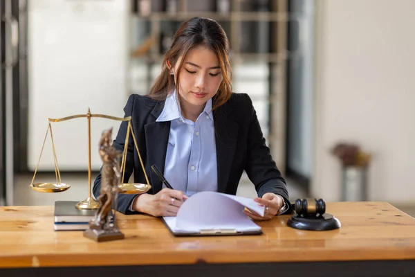 justice and law concept. Lawyer office. Statue of Justice with scales and lawyer Asian Woman working on a laptop. Legal law, advice and justice concept.