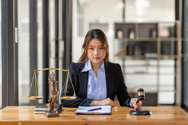 justice and law concept. Lawyer office. Statue of Justice with scales and lawyer Asian Woman working on a laptop. Legal law, advice and justice concept.