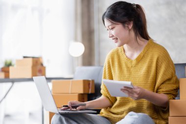 Portrait of Online business owner Asian female small businesses SME entrepreneur working at home, online marketing, packing boxes, SME sellers, concept, e-commerce team, online sales.