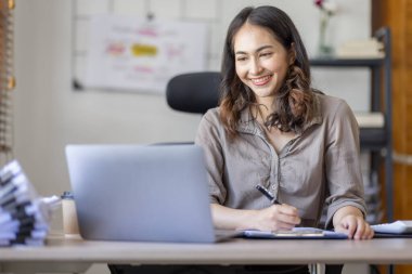 Asian businesswoman Accounting using calculating income-expenditure and analyzing real estate investment data report Financial and tax systems in workplace an home office.