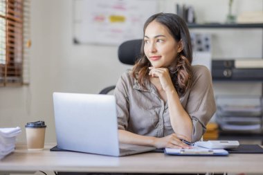 Asian businesswoman Accounting using calculating income-expenditure and analyzing real estate investment data report Financial and tax systems in workplace an home office.