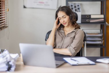 Asian indian women are stressed while working on laptop, Tired asian businesswoman with headache at office, feeling sick at work copy space in workplace an home office.