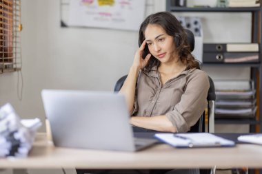 Asian indian women are stressed while working on laptop, Tired asian businesswoman with headache at office, feeling sick at work copy space in workplace an home office.