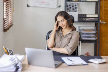 Asian indian women are stressed while working on laptop, Tired asian businesswoman with headache at office, feeling sick at work copy space in workplace an home office.