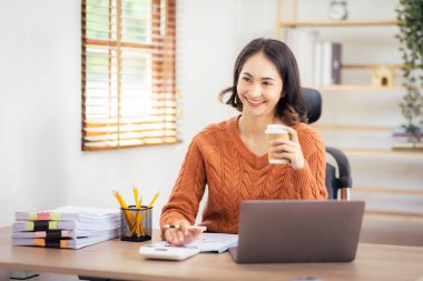 Freelancer Asian businesswoman Accounting work at home using calculating income-expenditure and analyzing real estate investment data report Financial and Documents tax systems concept.