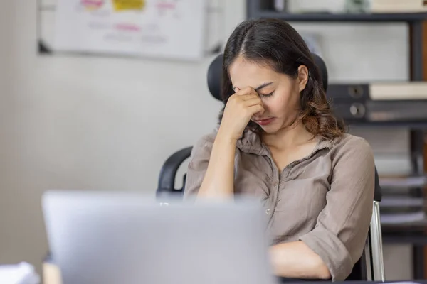 Asian indian women are stressed while working on laptop, Tired asian businesswoman with headache at office, feeling sick at work copy space in workplace an home office.