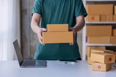 Close up of Hand man small business SME entrepreneur working at home, online marketing, packing boxes, SME sellers, concept, e-commerce team, online sales.