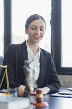 Statue of Justice and female lawyer in suit at workplace with laptop, gavel and femida in office. Law, legal services, advice, Justice and real estate concept.