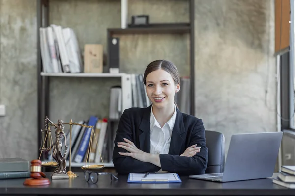 Statue of Justice and female lawyer in suit at workplace with laptop, gavel and femida in office. Law, legal services, advice, Justice and real estate concept.