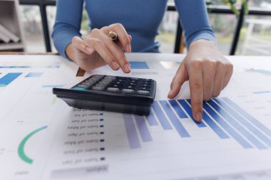 İş kadınına yakın çekim, iş prensiplerini hesaplamak için bir hesap makinesi kullanır. Ofisteki istatistiksel kavramlar finansal bir iş kuruyor, çevrimiçi pazarlama hesaplarını hesaplıyor.