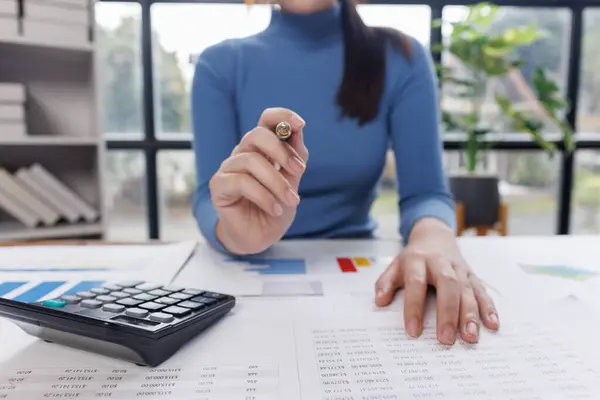 Muhasebe bankacılığı konsepti. Finans işleriyle ilgilenen bir iş kadını ve ofis masraflarını hesaplayan bir masa. Hesap makinesi ve mali muhasebe kullanan bir kadın..