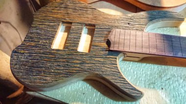 Henüz tamamlanmamış gövde, ahşap parçası ve fretboard stok elektrikli gitar el yapımı Luthier el işi atölyesi. 