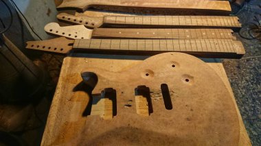 Henüz tamamlanmamış gövde, ahşap parçası ve fretboard stok elektrikli gitar el yapımı Luthier el işi atölyesi. 