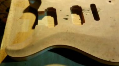 4k yukarı bakış açısı, tamamlanmamış gövde ve fretboard stoğu elektrikli gitar el yapımı Luthier el yapımı el işi atölyesi. 