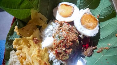 Meşe yaprağı tabanlı Pecel pilavı. Geleneksel bambu masasında bulunan tipik bir Java, Endonezya besin tezgahı.